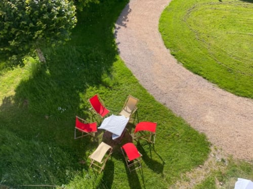 Aerial view of red and beige lounge chairs arranged on green lawn at Château de Vaux Morvan, a French countryside bed and