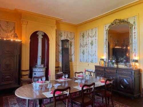 Élégante salle à manger du Château de Vaux Morvan aux murs jaunes, avec table ronde et mobilier d'époque à Étang-sur-Arroux