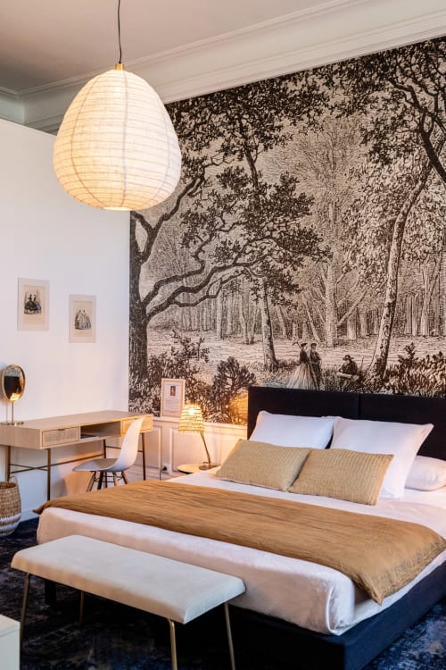 La chambre Mademoiselle de l'hôtel Henri II au Mans avec sa fresque forestière, lampe suspendue et mobilier contemporain