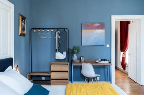 Chambre La belle Gabrielle à l'hôtel Henri II du Mans - murs bleus, bureau avec chaise, lit à couverture jaune et mobilier moderne
