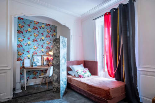 La chambre Marquee de l'hôtel Henri II au Mans dispose d'un lit à baldaquin bordeaux, d'un papier peint floral, d'un bureau et d'une vue sur la ville.
