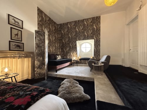 Chambre élégante de l'hôtel Henri II au Mans avec papier peint à motifs sombres, mobilier noir et équipements modernes