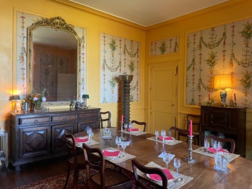 Élégante salle à manger du Château de Vaux Morvan aux murs jaunes, table dressée raffinée et mobilier d'époque à Étang sur