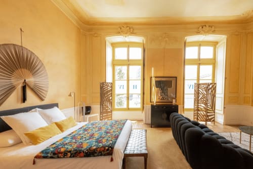 Suite Marquis luxueuse à l'hôtel Henri II au Mans : murs dorés, vue sur jardin et mobilier élégant