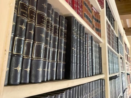 Livres anciens reliés en cuir sur étagères en bois à la bibliothèque du Château de Vaux Morvan, Étang sur Arroux France