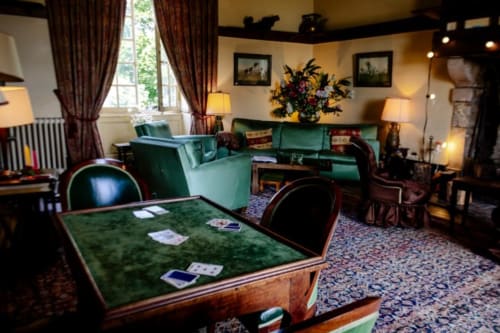 Élégant salon du Château de Vaux Morvan avec sièges en velours vert, table de jeu et mobilier d'époque à Étang sur Arroux
