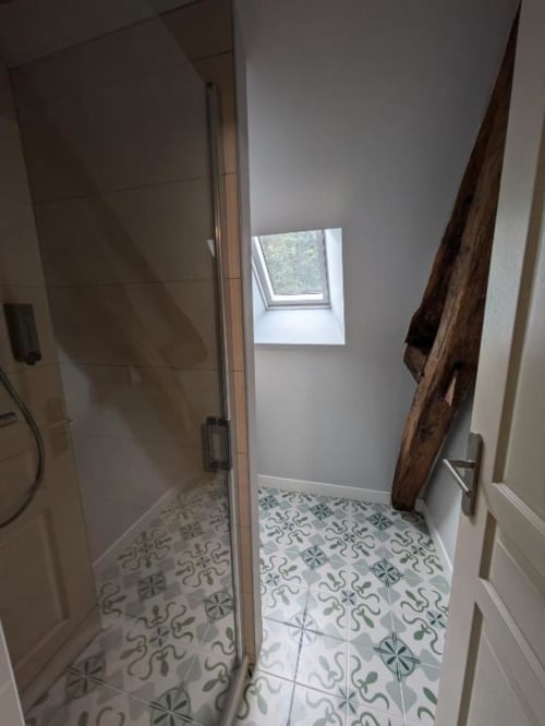 Salle de bain moderne avec carrelage à motifs, douche vitrée et puits de lumière au manoir Saint Joseph à Sens