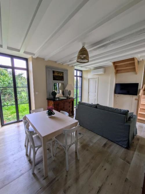 Salon et salle à manger de la villa moderne au Manoir Saint Joseph avec vue sur le jardin, cheminée et mobilier contemporain