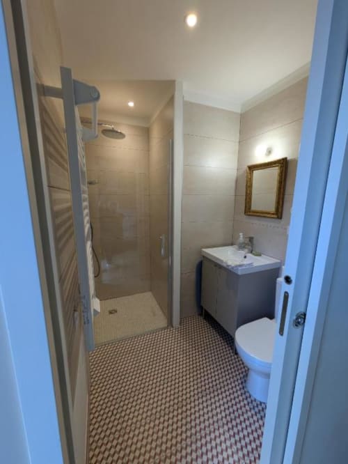 Salle de bains moderne au gîte Manoir Saint Joseph avec douche, vasque, toilettes et carrelage géométrique