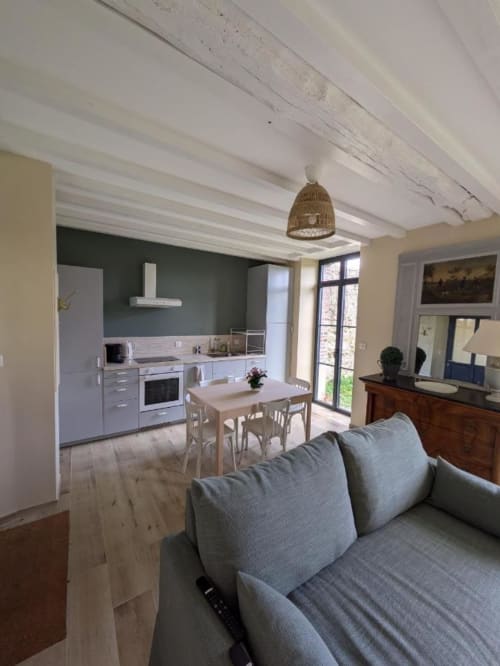Open-plan living area at Manoir Saint Joseph in Sens with kitchen, dining table, and sofa
