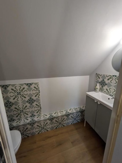 Salle de bains moderne avec carrelage décoratif bleu et blanc, lavabo blanc et toilettes à la maison d'hôtes Manoir Saint Joseph
