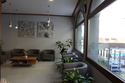 Lobby moderno del Hotel Rego Foz en Lugo con asientos, lámparas colgantes y obras de arte botánico