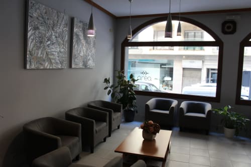 Recepción moderna del Hotel Rego Foz en Lugo con asientos de cuero negro, iluminación colgante y ventanales hacia la calle