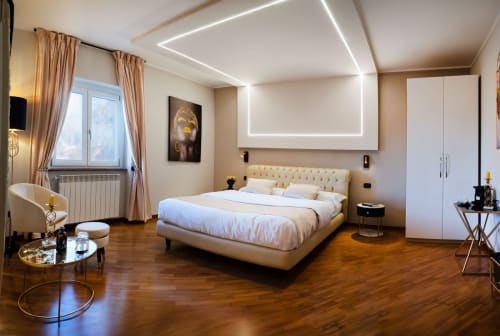 Camera da letto lussuosa a Villa Del Sole Inn a Campobasso con letto color crema, illuminazione neon moderna, pavimenti in legno e design contemporaneo