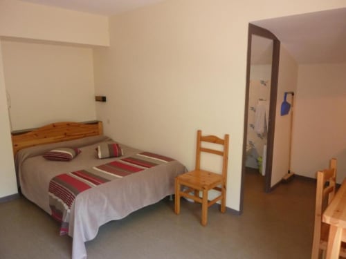 Studio douillet aux Studios La Rochetaillée à Brides-les-Bains avec lit en bois, mobilier rustique et vue montagne
