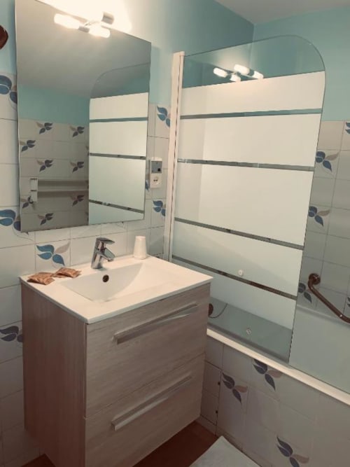 Salle de bains moderne aux Studios La Rochetaillée à Brides-les-Bains : vasque, miroir et douche à l'italienne