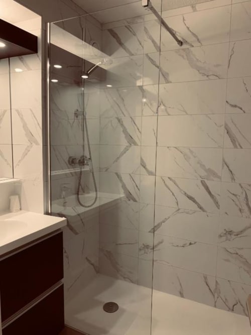 Salle de bains moderne avec douche carrelage imitation marbre, paroi vitrée et vasque aux Studios La Rochetaillée, Brides-les-Bains