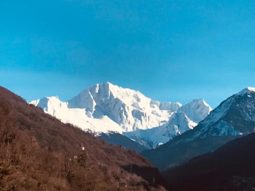Pics alpins enneigés dominant la vallée de Brides-les-Bains, forêts sur les versants, ciel bleu dégagé