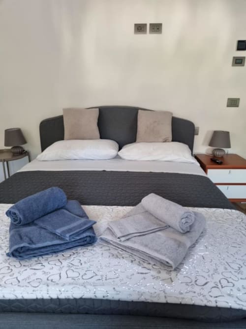Camera da letto al Maso Kreuzberg B&B di Trento con asciugamani arrotolati sul letto e arredi moderni