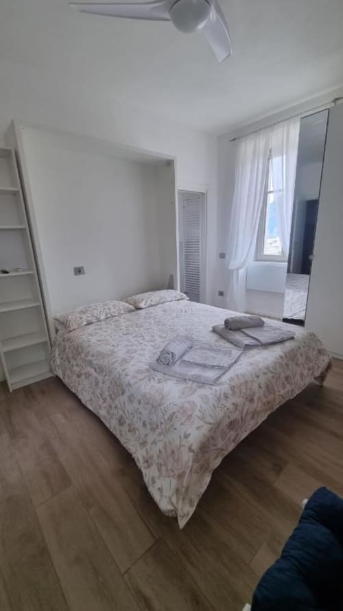 Camera luminosa e moderna presso il Maso Kreuzberg B&B a Trento con letto matrimoniale, pareti bianche, ventilatore a soffitto e armadio con specchio