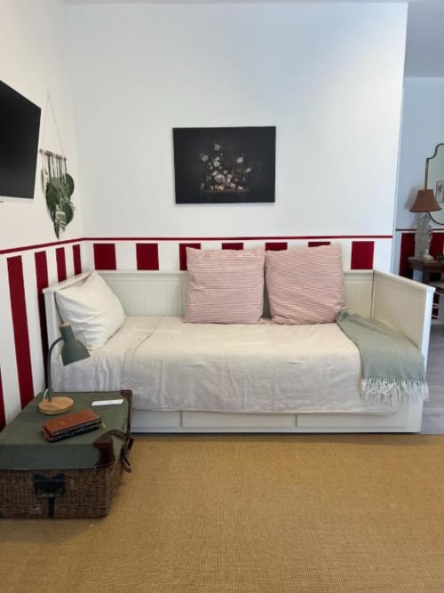 Dalia room at La Cascina di Bea B&B features a white daybed with red striped headboard, pink cushions, and cream bedding in