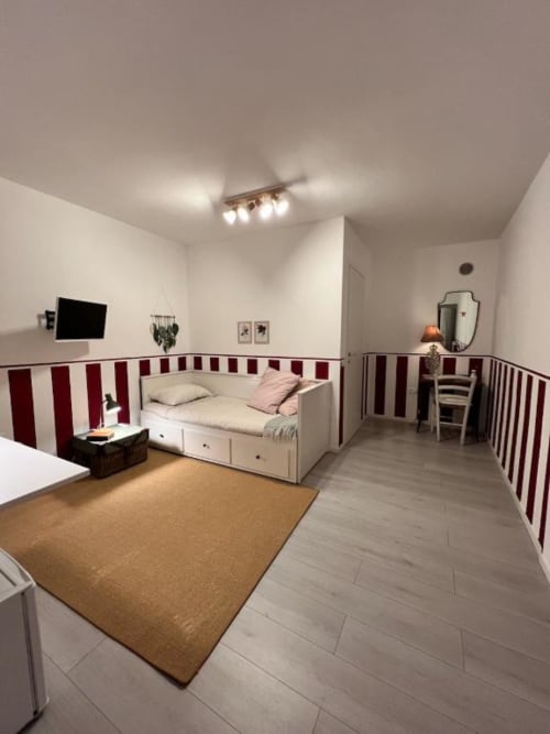 Camera moderna a La Cascina di Bea B&B a Bergamo con letto daybed, parete a righe rosse e bianche, pavimento in legno