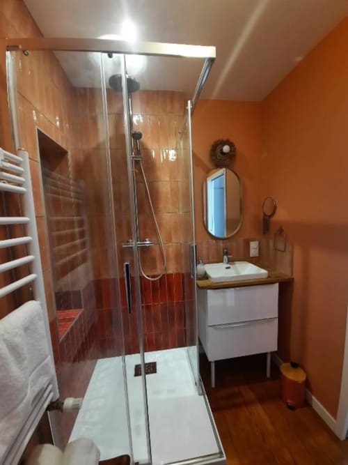 Salle de bain moderne de la Maison Rinette B&B à Dijon avec murs orange, douche spacieuse et vasque blanche