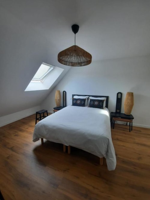 Chambre mansardée moderne à la Maison Rinette Dijon avec puits de lumière, suspension tissée et parquet