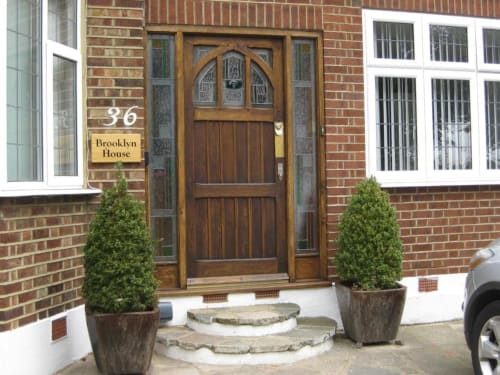 Brooklyn House entrance in Southgate London with wooden door, topiary plants, and brick facade