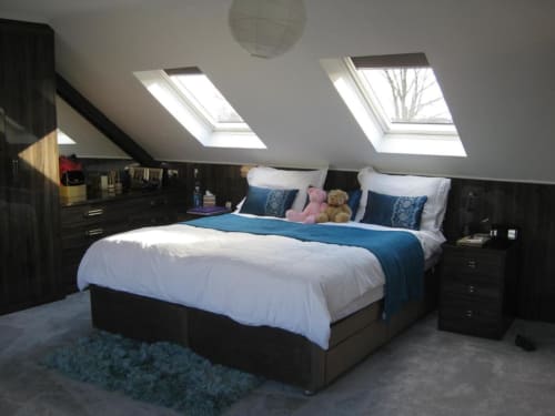 Bright attic bedroom at Brooklyn House with double bed, black furniture, skylight windows, and garden view in Southgate,