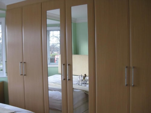 Modern wooden wardrobe with mirrored doors in Deluxe King Room at Brooklyn House, London B&B