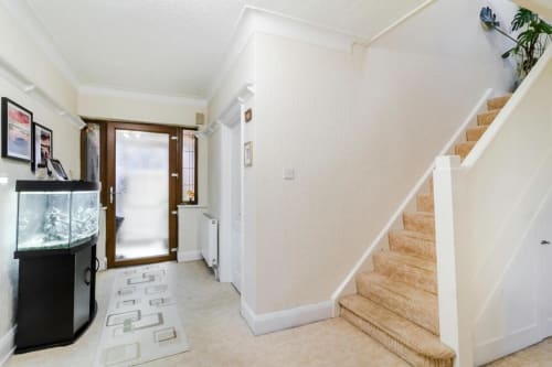 Bright hallway entry at Brooklyn House B&B Southgate London, with staircase, aquarium and glass doors