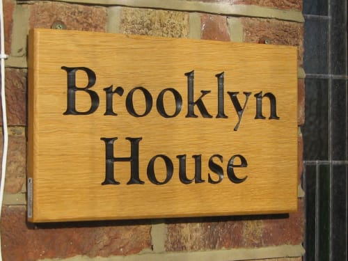 Brooklyn House wooden sign on brick wall, Southgate London bed and breakfast entrance