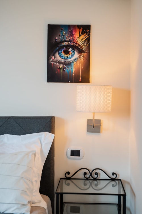 Camera moderna della Villa Del Sole Inn con opera d'arte colorata, applique murale e comodino a Campobasso