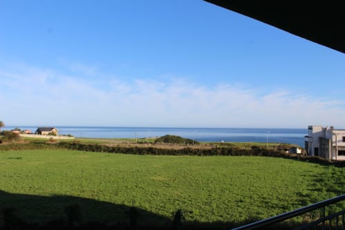 Prado verde con vistas al océano desde el balcón de Apartamentos Los Gemelos en Foz, Galicia