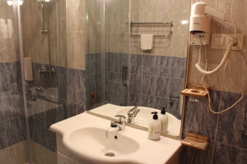 Baño moderno en Apartamentos Los Gemelos en Foz con cabina de ducha, lavabo blanco y amenities