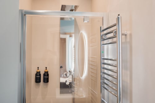 Moderno box doccia a Villa Del Sole Inn con specchio rotondo e scaldasalviette elettrico a Campobasso