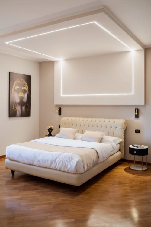 Camera da letto di lusso moderno a Villa Del Sole Inn con letto rivestito in crema, testata luminosa al neon e vista giardino a Campobasso