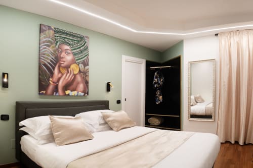 Camera moderna della Villa Del Sole Inn a Campobasso con pareti verde salvia, letto bianco e opere d'arte africane