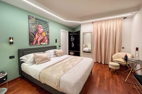 Camera moderna di Villa Del Sole Inn a Campobasso con pareti verde menta, letto king e vista giardino