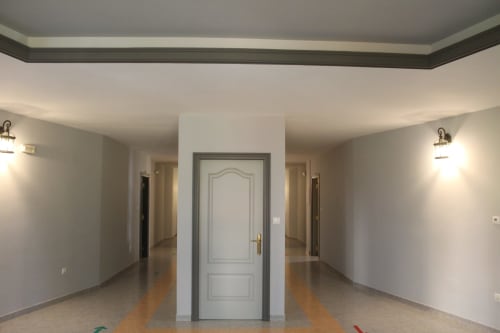 Pasillo moderno en Apartamentos Los Gemelos en Foz, Lugo con puerta central y corredores simétricos