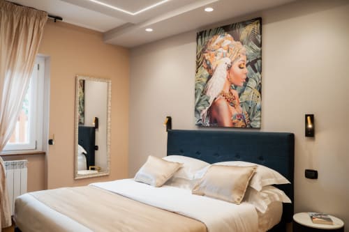 Camera moderna della Villa Del Sole Inn a Campobasso con testata scura, biancheria crema e decorazioni botaniche