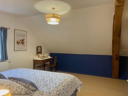 Spacious bedroom at Château de Vaux Morvan with bed, desk, and navy accent wall in Étang sur Arroux