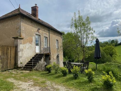 Rustic stone cottage with patio seating at Château de Vaux Morvan B&B in Étang sur Arroux, France