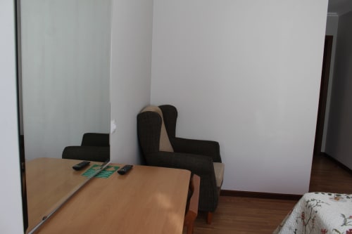 Habitación del Hotel Rego Foz con escritorio de madera, silla negra y paredes blancas en Foz, Lugo