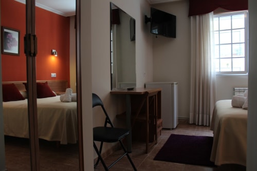 Habitación moderna del Hotel Rego Foz en Foz, Lugo con camas gemelas, escritorio, TV y armario con espejo