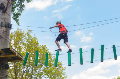 Person on zip line course at Brooklyn House adventure activity in Southgate, London