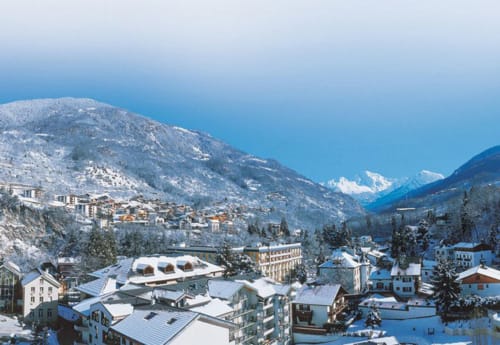 Snowy alpine village of Brides-les-Bains with mountain-view chalets and ski resort in French Alps
