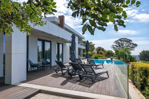 Deck moderno da Casa Da Colina com espreguiçadeiras, piscina e vistas para as montanhas em Caldas De Monchique