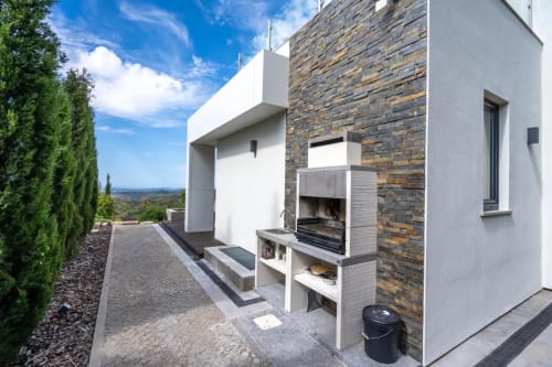 Fachada moderna do hotel Casa Da Colina em Caldas De Monchique com lareira de pedra e arquitetura branca